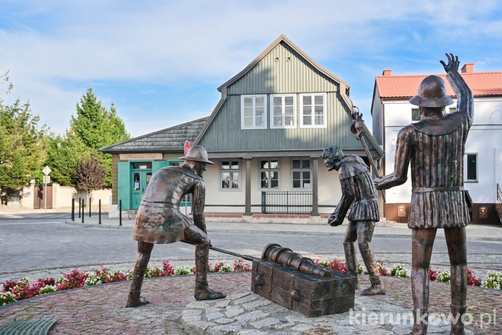 rynek w pyzdrach rzeźba artylerzystów pierwszy wystrzał z armaty na tle domu podcieniowego ciekawe miejsca i atrakcje w pyzdrach