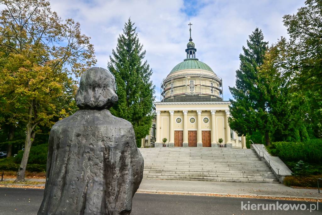 Kościół św. Jana Vianneya w Poznaniu. Przed kościołem stoi rzeźba patrona świątyni.
