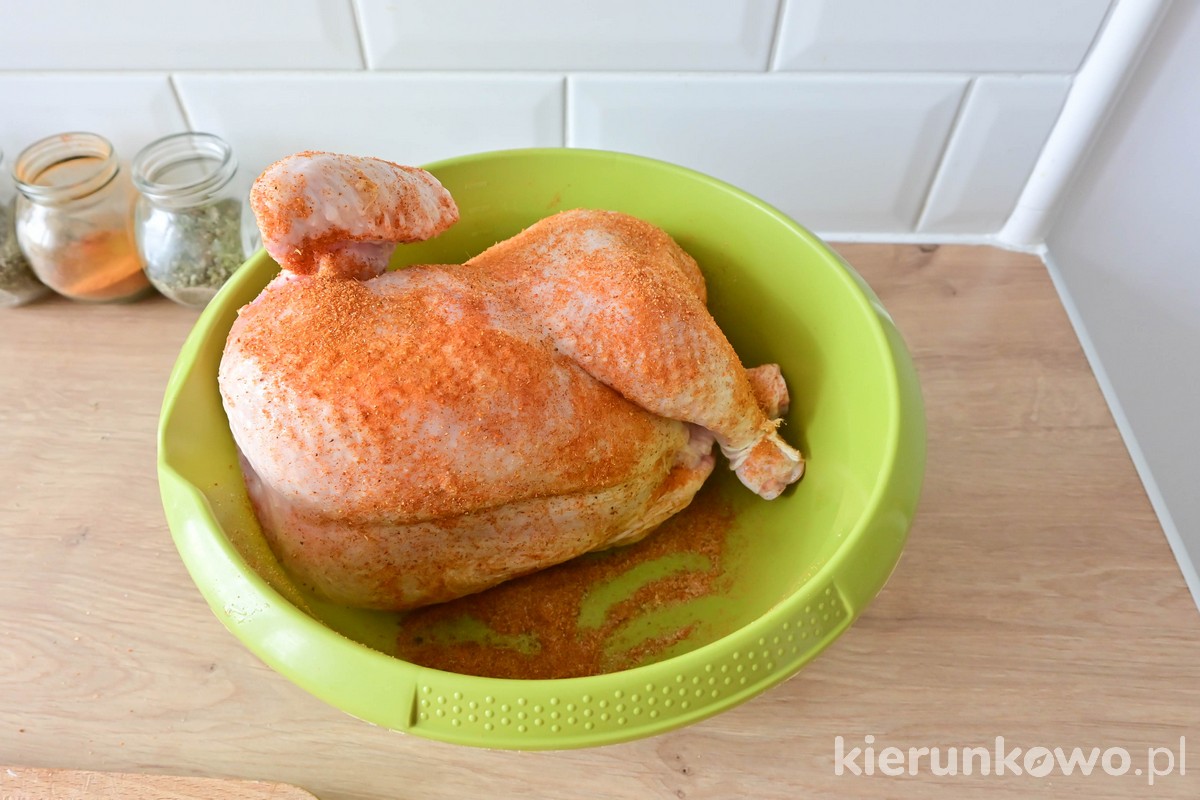 obtaczanie całego kurczaka w przyprawach przed pieczeniem