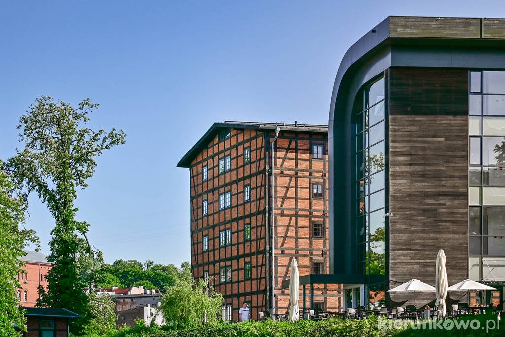 Nowoczesny budynek Przystani Bydgoszcz (na 1. planie) i wyłaniający się zza niego zabytkowy Spichlerz Zbożowy Młynów Rothera