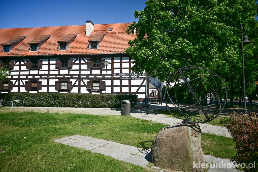 Pomnik 18. południka na tle Białego Spichlerza (obecnie muzeum)